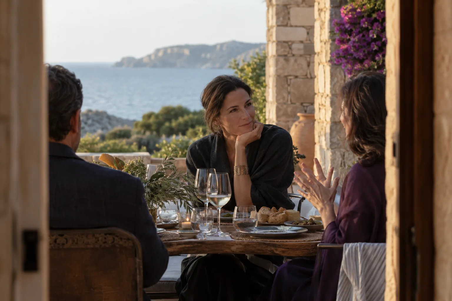 A female founder aged 42 listening to another guest at an intimate private Italian dinner