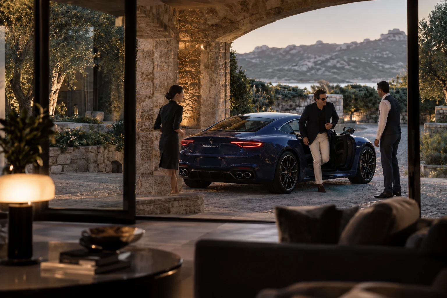 Illustrative scene: a host receiving an arriving leader beside a sapphire Maserati GranTurismo beneath a stone arch